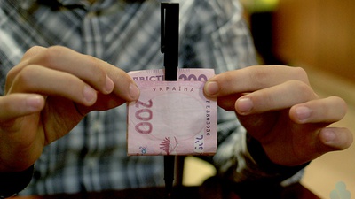 Ручка крізь купюру