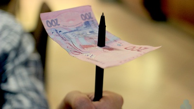 Ручка крізь купюру