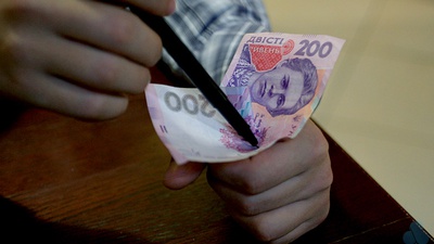 Ручка крізь купюру