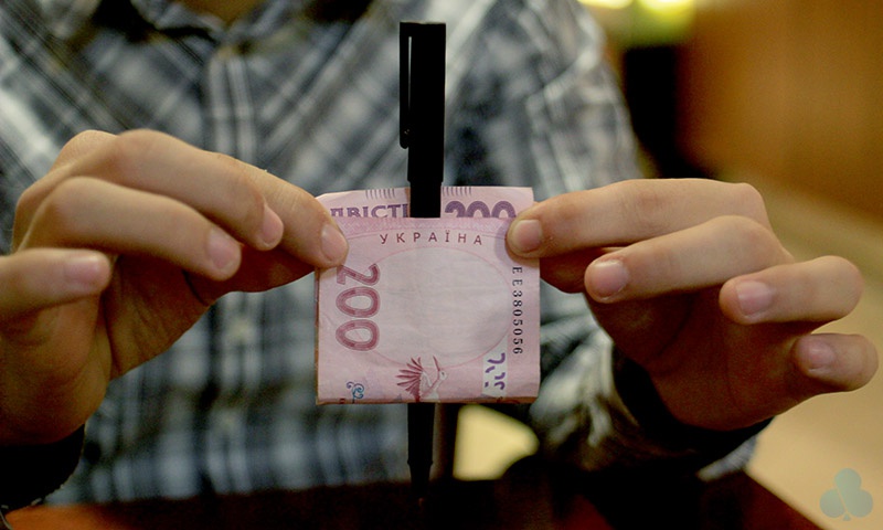 Ручка крізь купюру