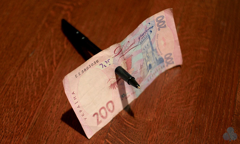 Ручка крізь купюру