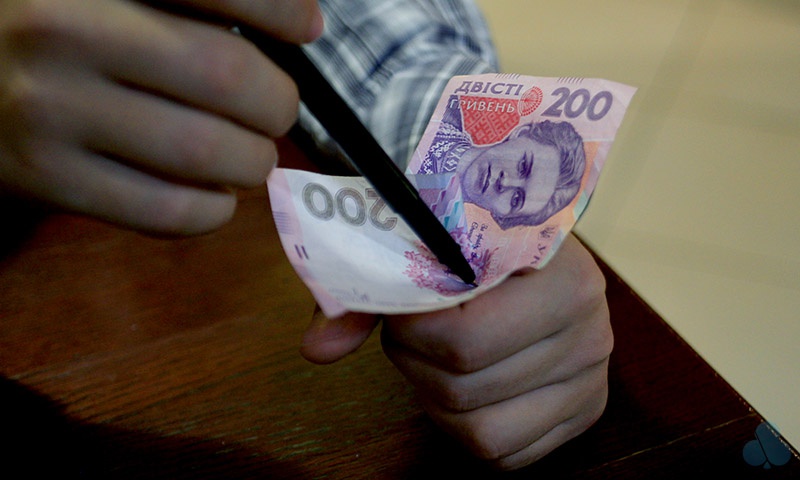 Ручка крізь купюру